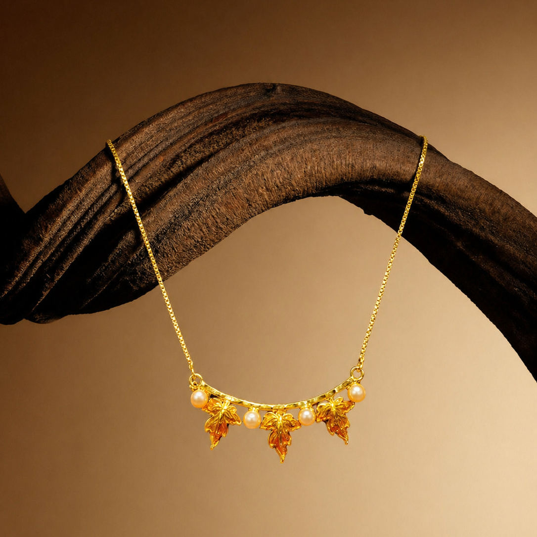 Gold necklace with floral design on a wooden surface
